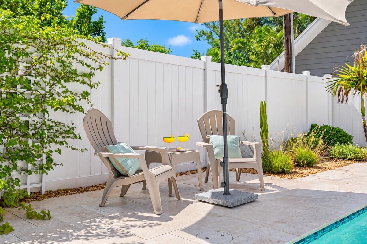 Lounge in luxury with in-water sun chaises, vibrant landscaping, and total privacy behind a fenced yard.