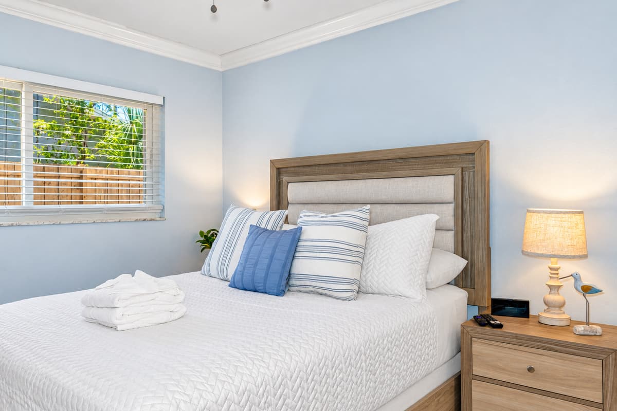 This inviting space features a cozy queen-size bed, complete with a plush mattress and soft, high-quality linens that promise comfort and relaxation.