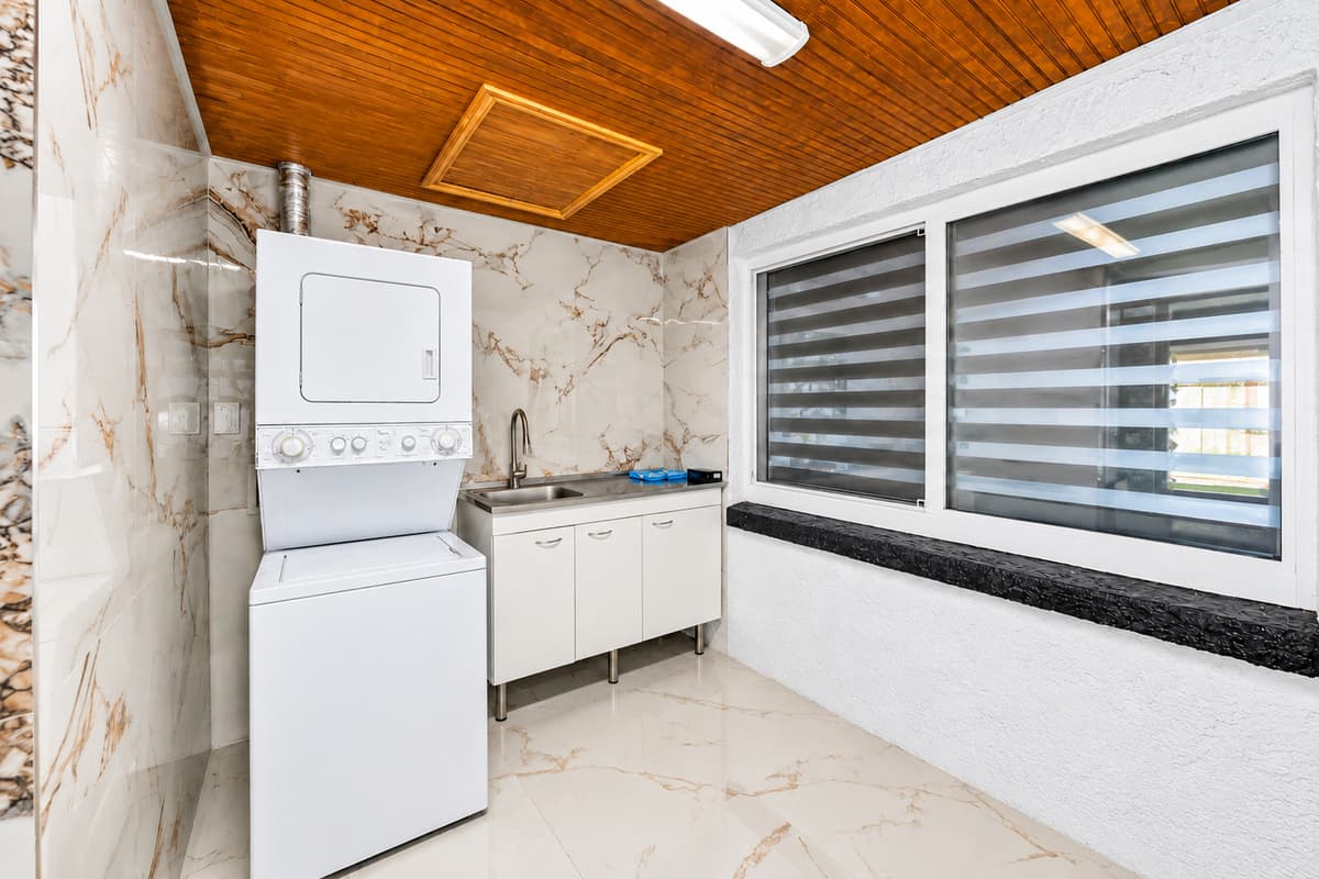 Convenient laundry area featuring a washer and dryer, utility sink, and plenty of space for handling laundry during extended stays.