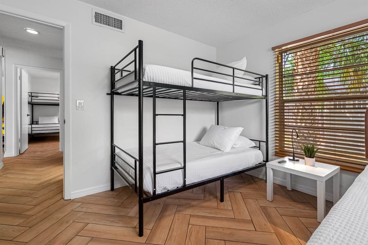 A queen-size bed and a bunk bed offers ample sleeping space without compromising on style. Natural light and a mounted TV add to the comfort.