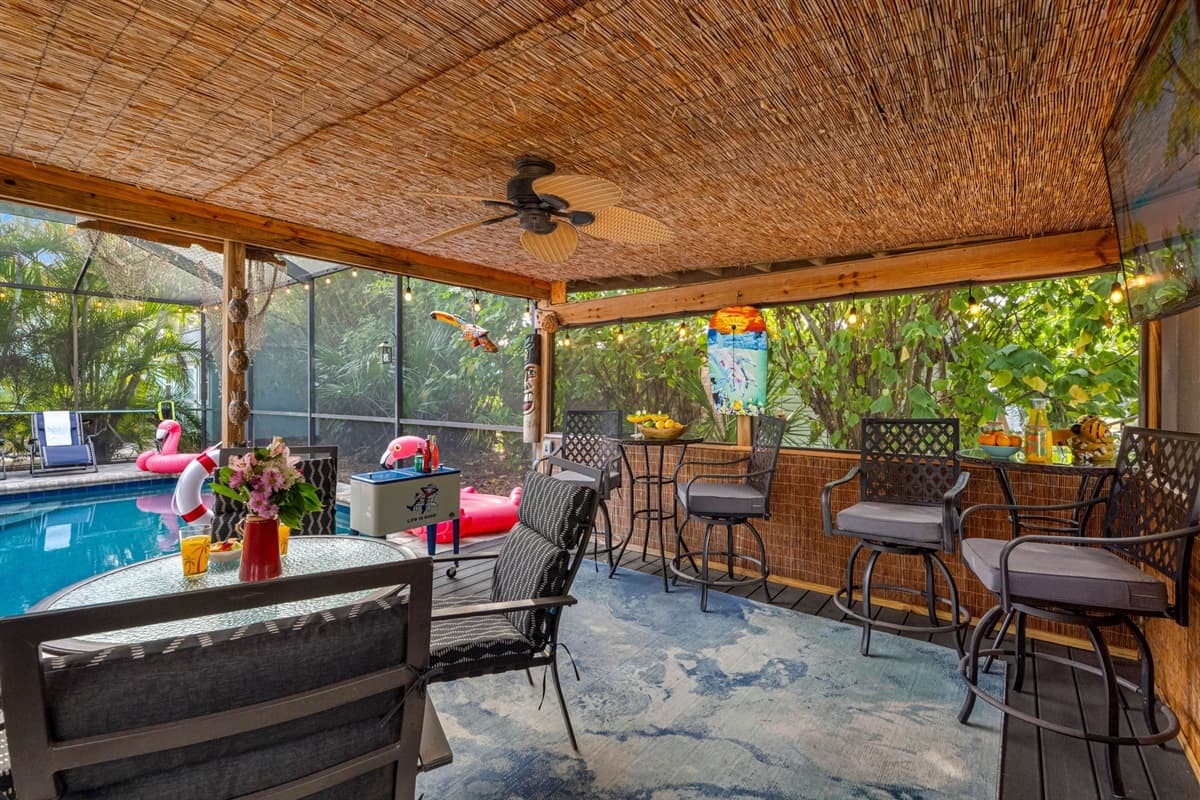 Enjoy the peaceful outdoor ambiance in this shaded patio retreat, complete with soft overhead lighting, gentle ceiling fan breezes, and lush natural surroundings.