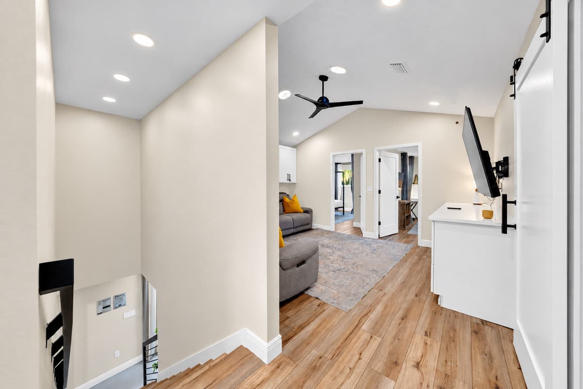 Space between the rooms is the whole point. Wide, light-filled passages connecting the wings, so a house holding eighteen people never feels like a house holding eighteen people.
