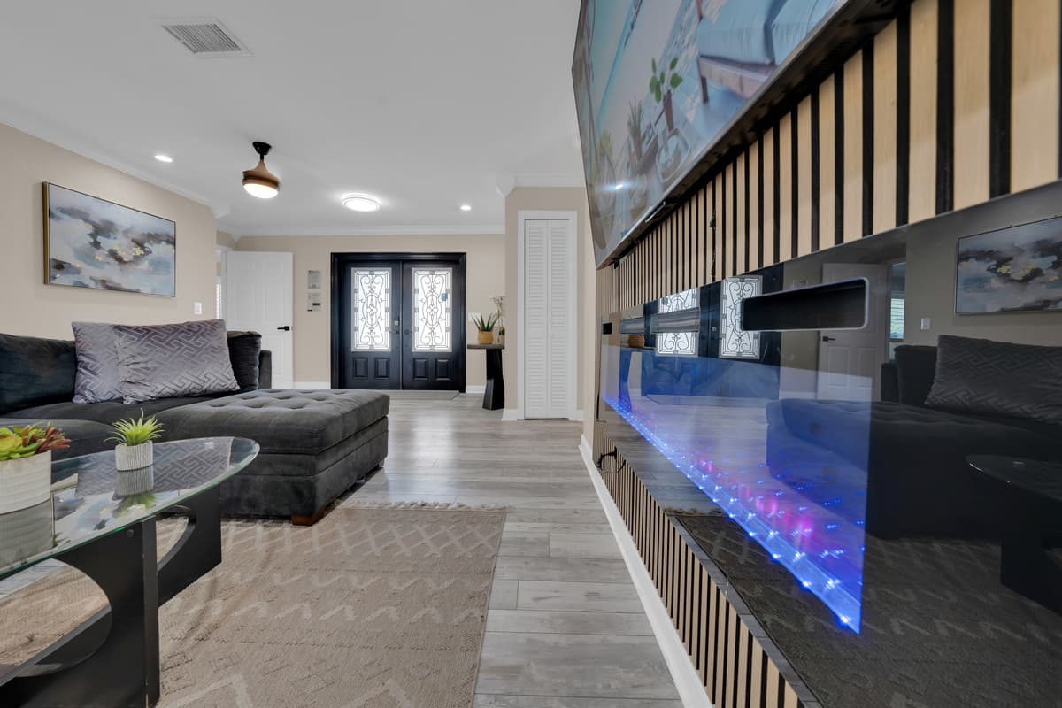 A sleek linear fireplace glows blue against the wall, adding a cozy, modern touch to movie nights in