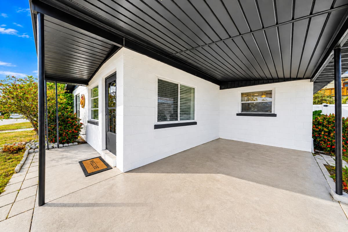 Spacious covered carport and front patio area with convenient sheltered entry access.