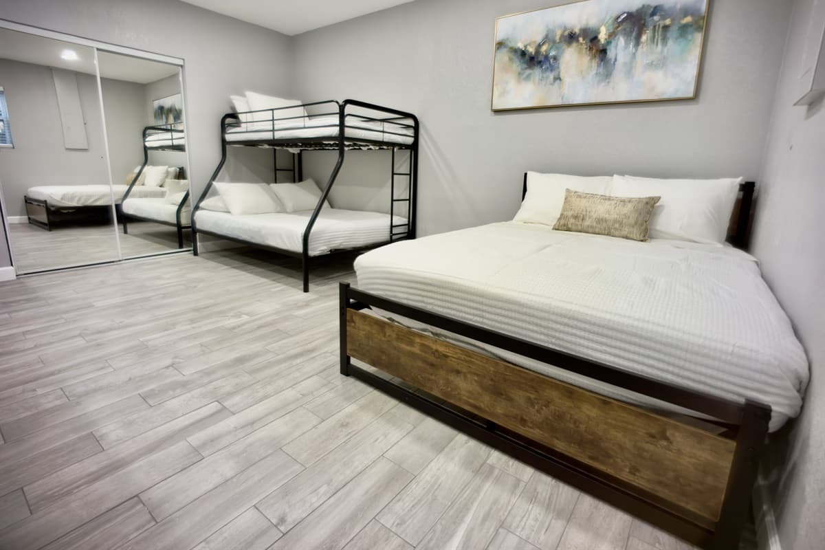 A spacious and inviting retreat with a queen-size bed, and a bunk bed, perfect for relaxation and restful nights.