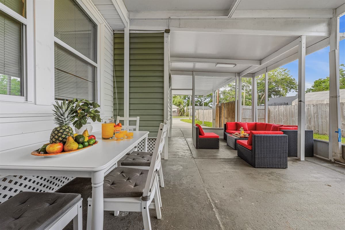 Covered outdoor lounge with dining table and seating—perfect for relaxing or enjoying meals outside.