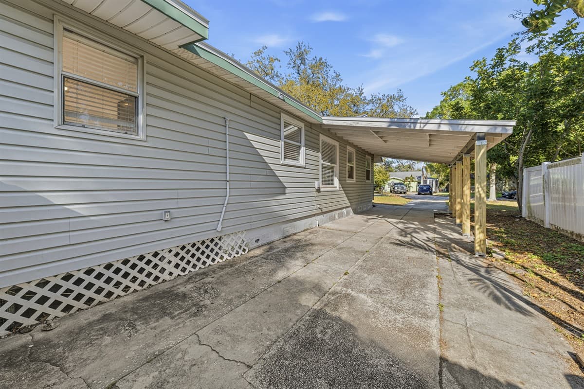 Long driveway/side yard with covered parking access.