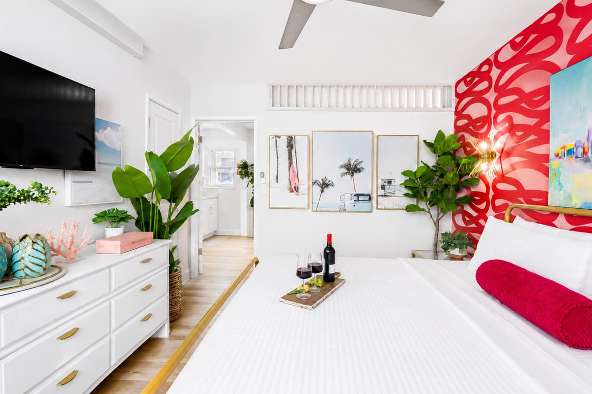 Enjoy a restful night's sleep in the spacious bedroom with a plush king bed, Smart TV, dresser, and tropical-inspired accents.