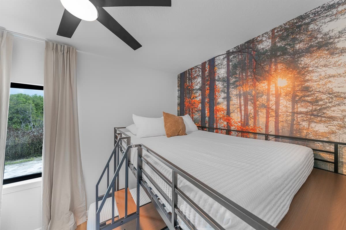 Additional sleeping area with a cozy bed and scenic accent wall, creating a warm and inviting space.