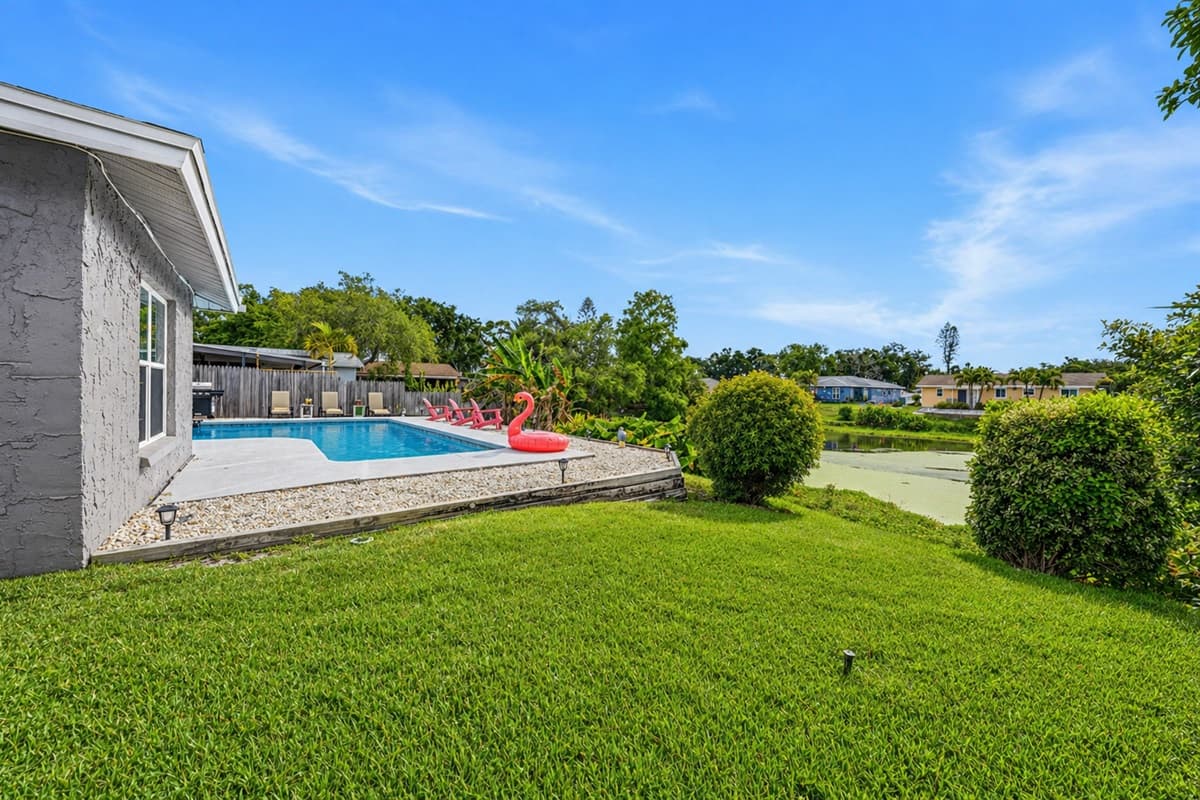 Spacious backyard with lush green lawn and direct views of the pool area—perfect for relaxing outdoors.