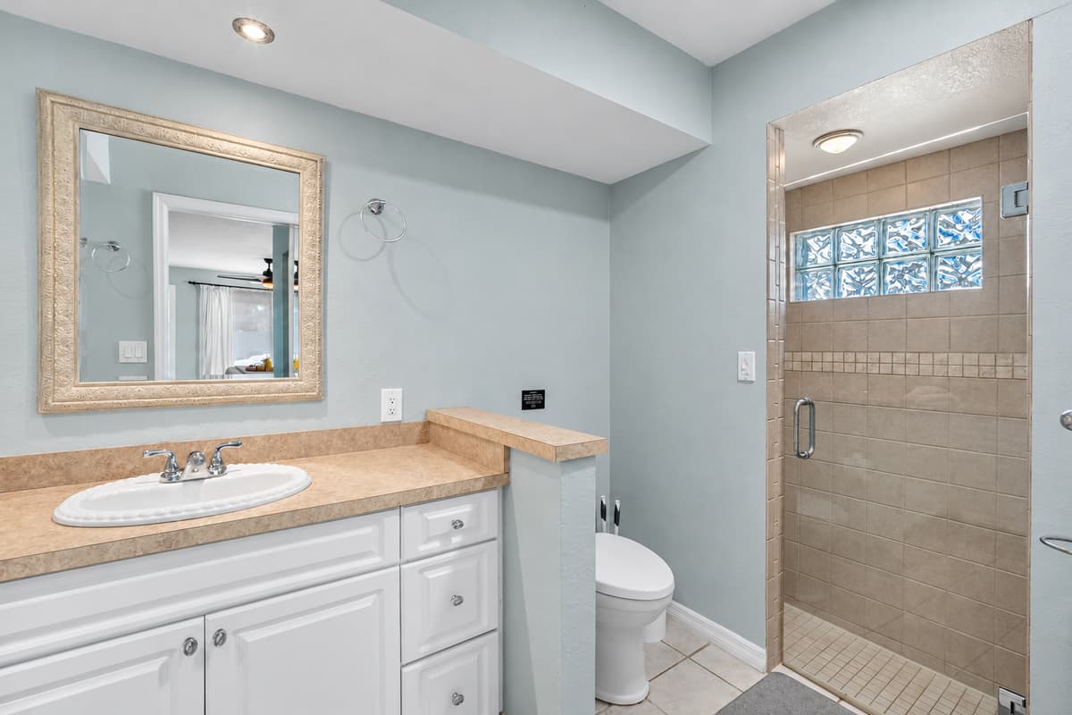 This bathroom combines style and practicality with twin sinks and a beautifully tiled shower.