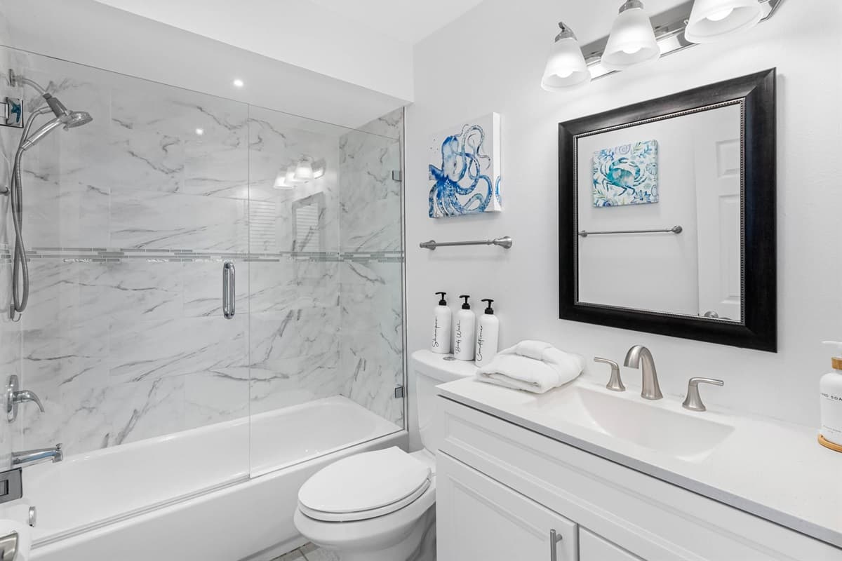 Enjoy a hotel-like experience with modern lighting, glass enclosure, and a spacious vanity.