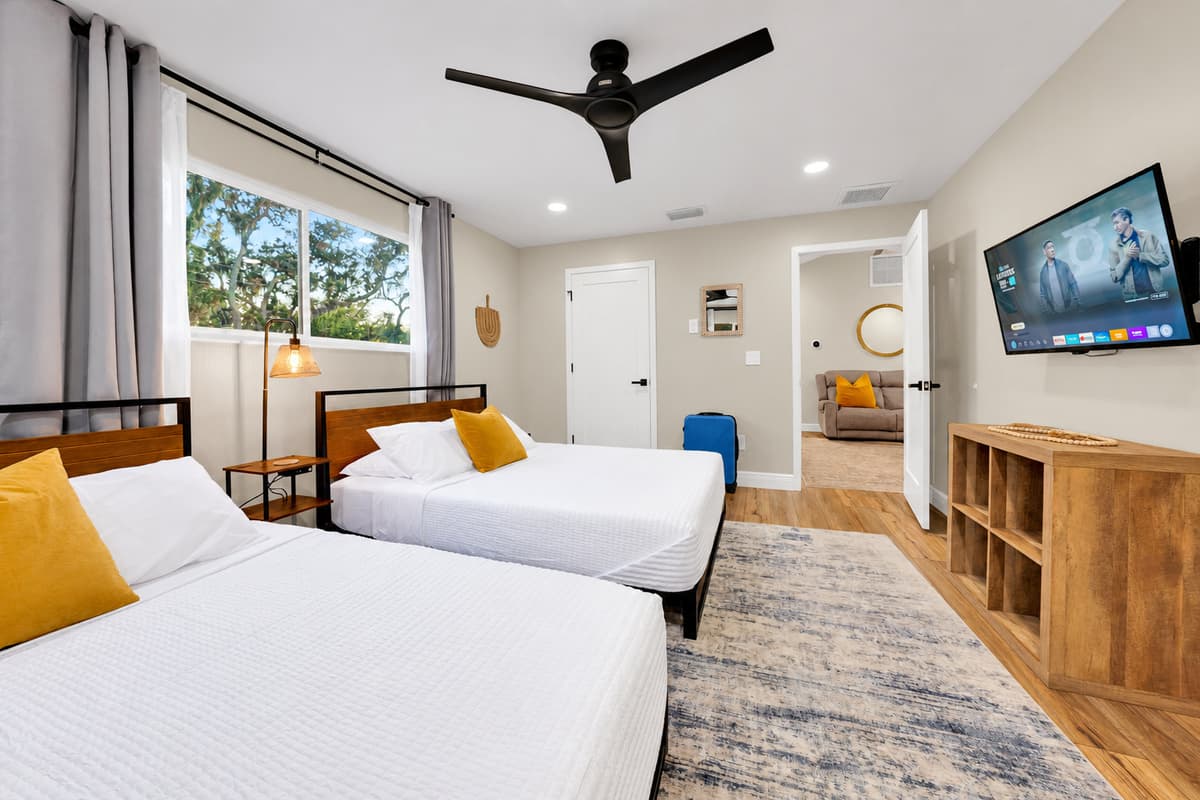 Two queens, a smart TV and a view of the trees. Bright, vaulted and spacious enough for four to share without stepping over each other's bags — with the bathroom just past the door.