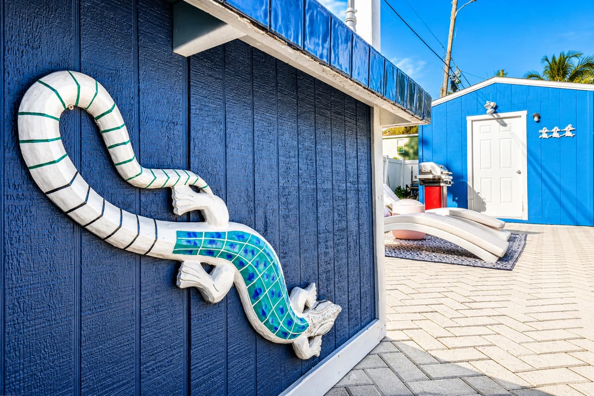 Decorative coastal-themed exterior accent featuring a nautical rope sculpture mounted on the vibrant blue pool house.
