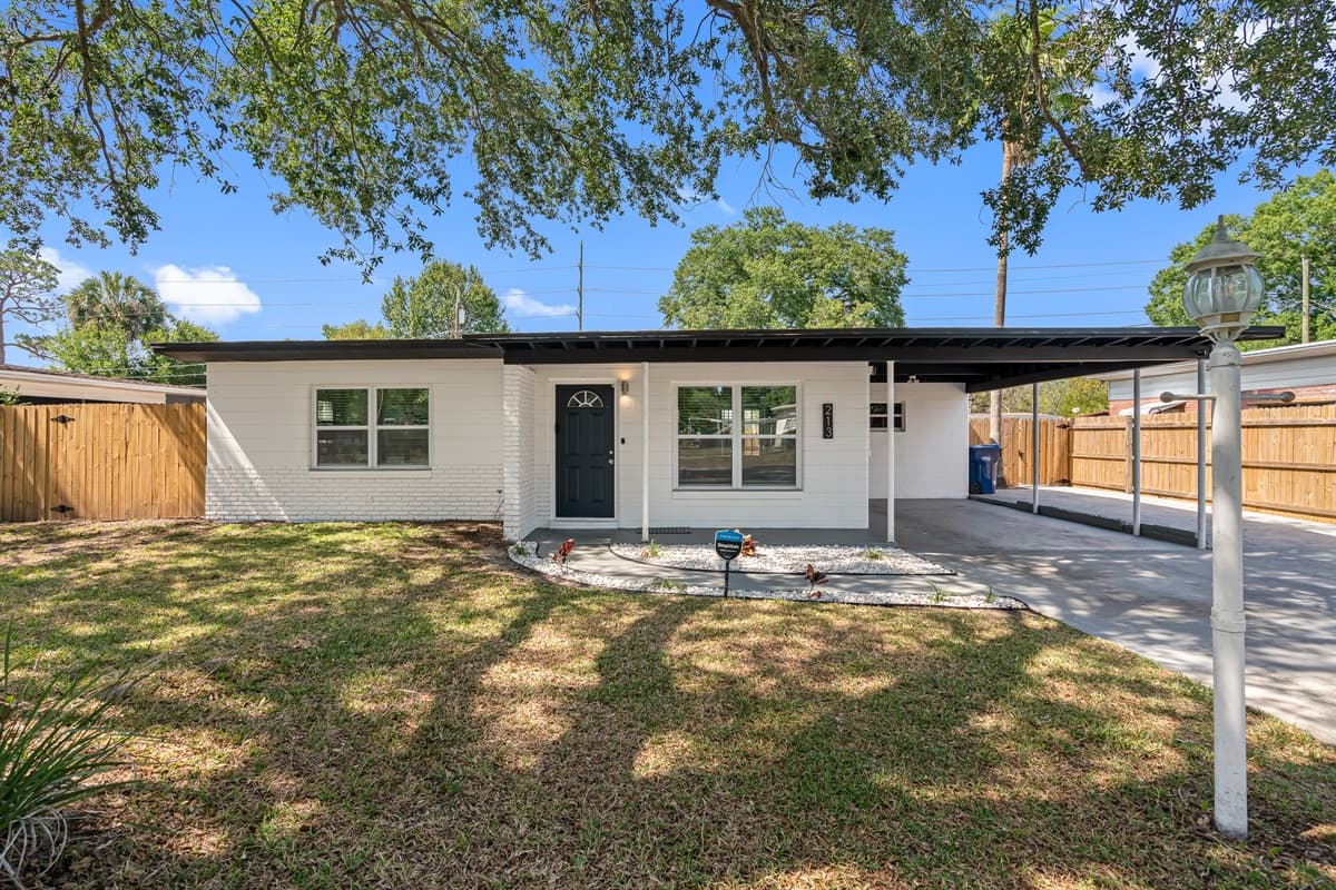 As you pull up to the front of the property, you'll be greeted by a lush green lawn and a spacious driveway.