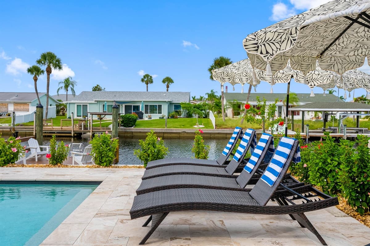 Spacious pool deck with Adirondack chairs invites you to lounge waterside all day long.