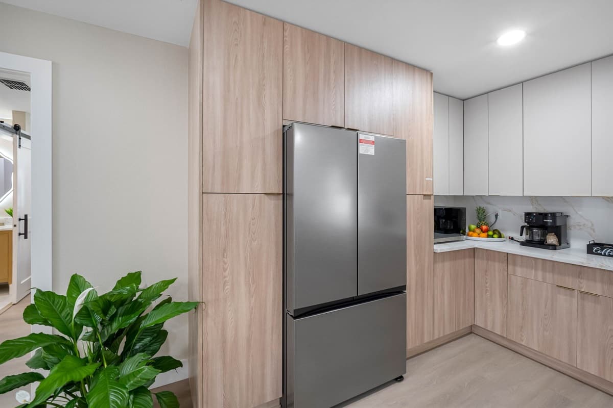 Simplicity meets luxury in this Scandinavian-inspired kitchen, highlighted by light wood tones, soft neutral cabinetry, and marble-style countertops. The design exudes calm and balance — perfect for modern living.