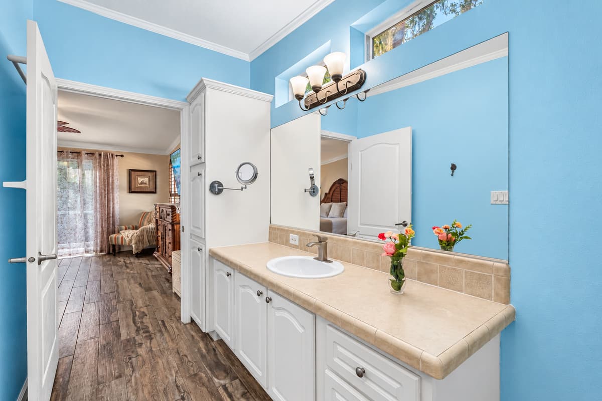 Calming sky-blue walls, tasteful artwork, and warm natural-wood flooring create a soothing coastal ambiance throughout.