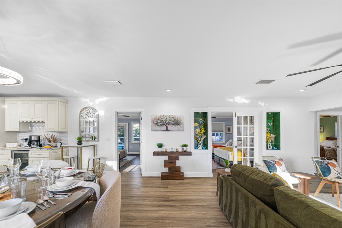Enjoy gathering in this sun-filled living room, complete with a comfortable sectional, stylish coffee tables, and a warm, welcoming vibe.