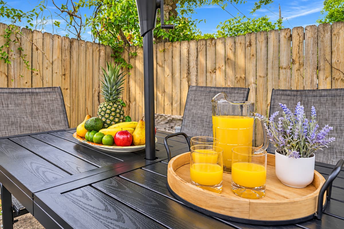 Close-up of outdoor dining setup with umbrella and fresh, inviting table setting.