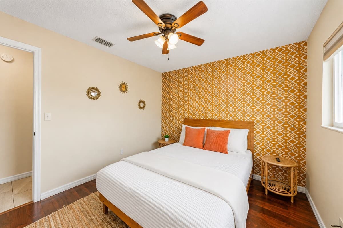 Bright and inviting space with wall-mounted TV, ceiling fan, and relaxing ambiance.