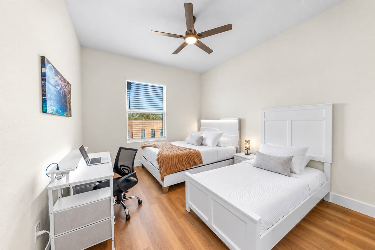 Comfortable bedroom with two beds and workspace—great for extended stays.