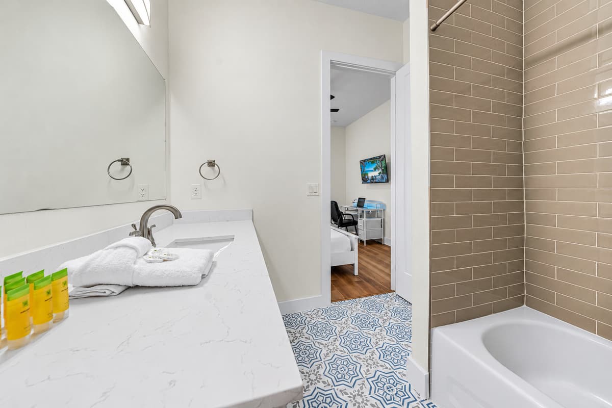 Bathroom 2 (en suite): tub/shower combination with fresh towels and toiletries.