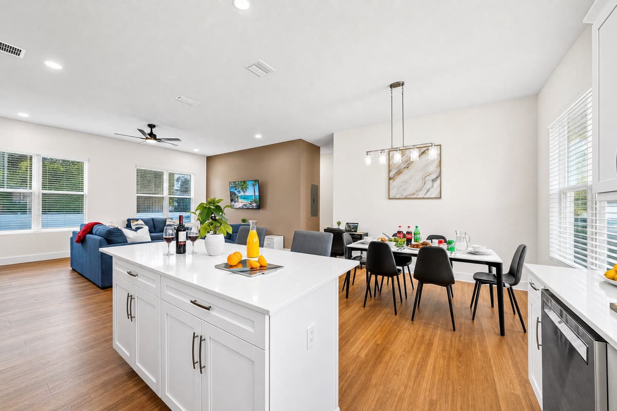 Bright open-plan living with windows on both sides, a smart TV, and seating everywhere you look.