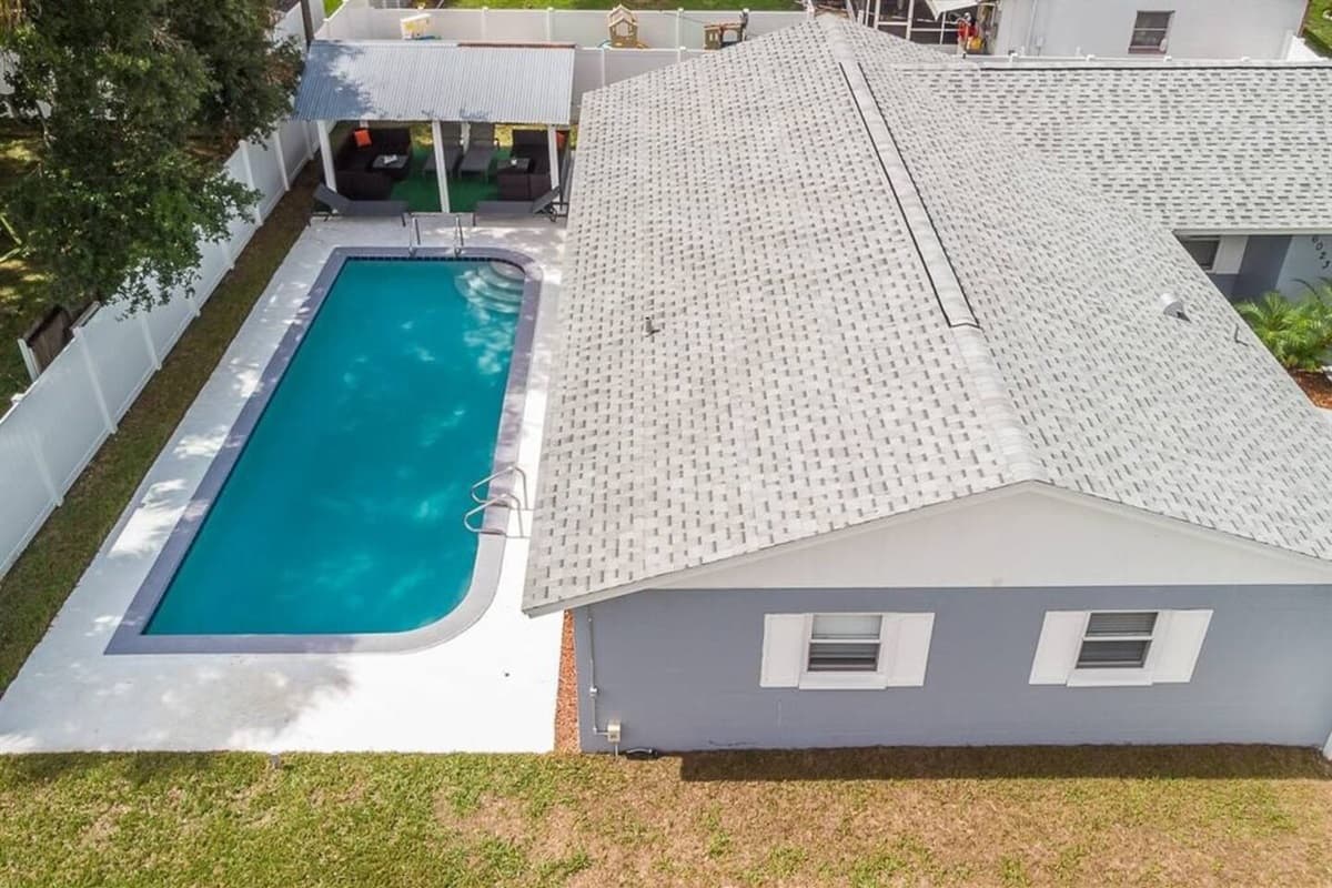 Aerial back view of the property showcasing the beautiful heated pool and the beautiful fully fenced backyard where kids can play safely.. Don't miss the opportunity and book now!