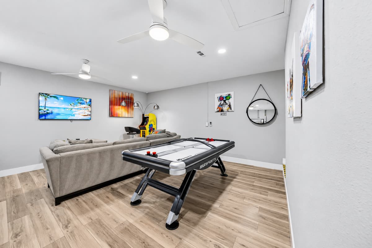 Open-concept game room with Smart TV, air hockey table, and plenty of seating.