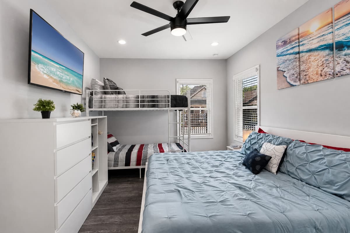 Beautiful bedroom with a bunkbed, king sized bed, drawers for storage and smart TV. Ideal room for a family with kids or a group of friends.