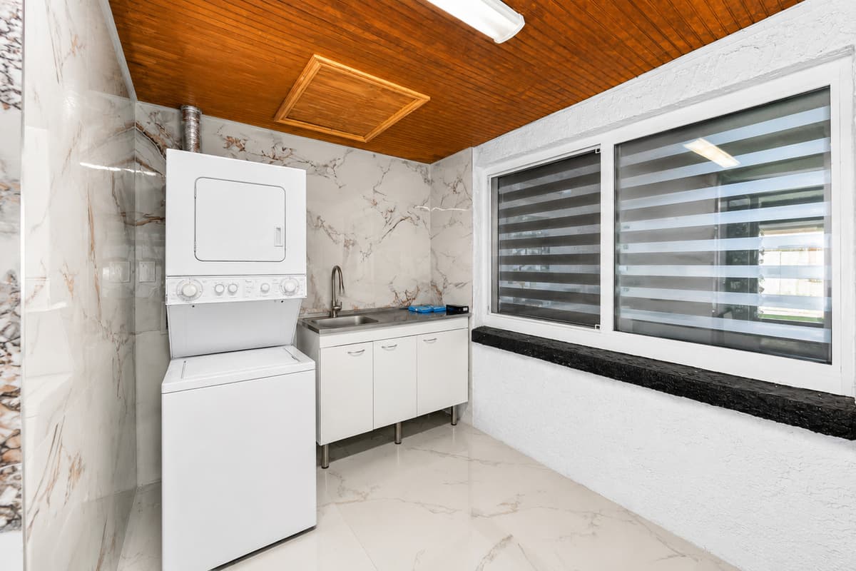 Convenient laundry area featuring a washer and dryer, utility sink, and plenty of space for handling laundry during extended stays.