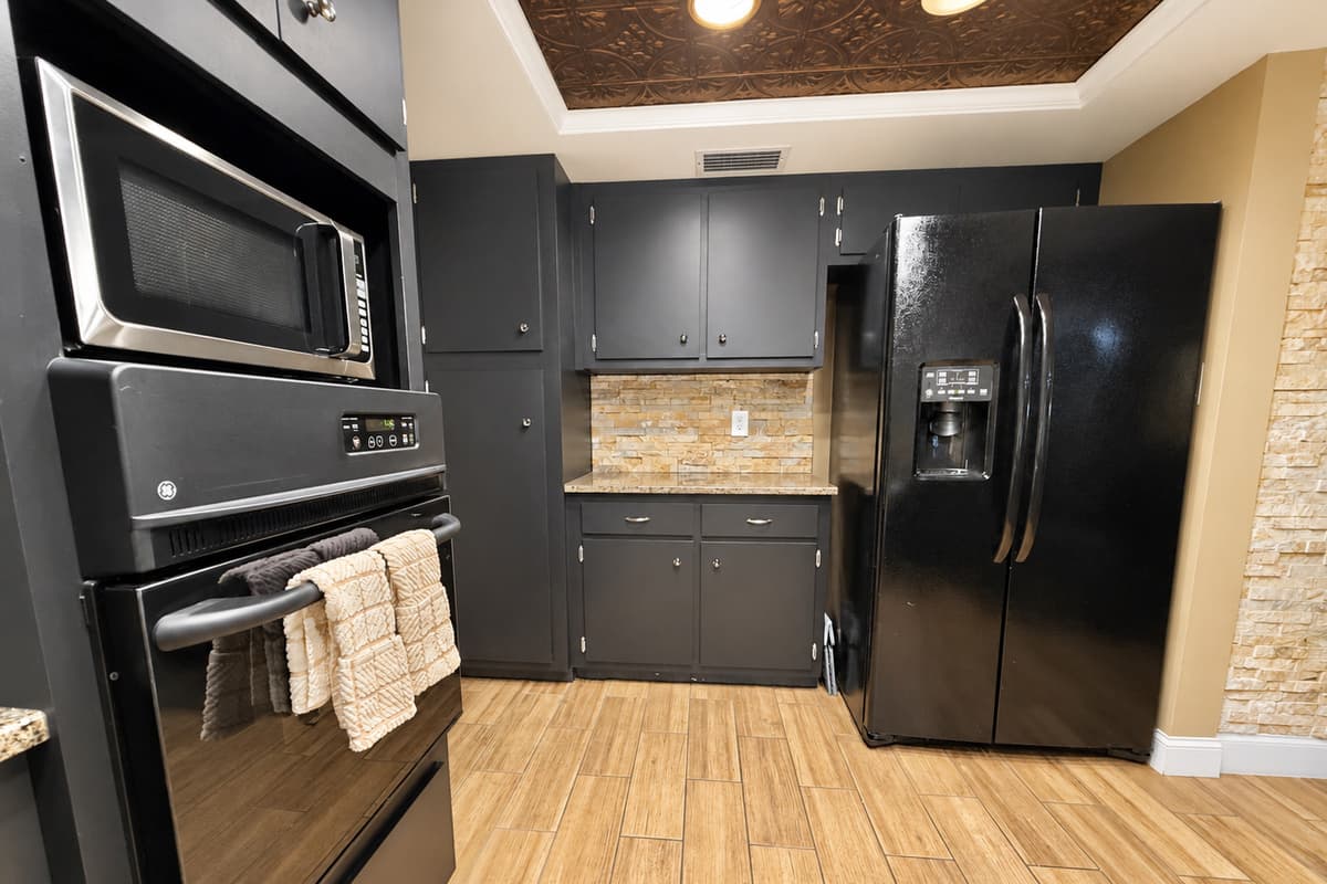 You'll love the layout that offers generous counter space, plenty of storage, and a full suite of stainless and black appliances to meet all your culinary needs.