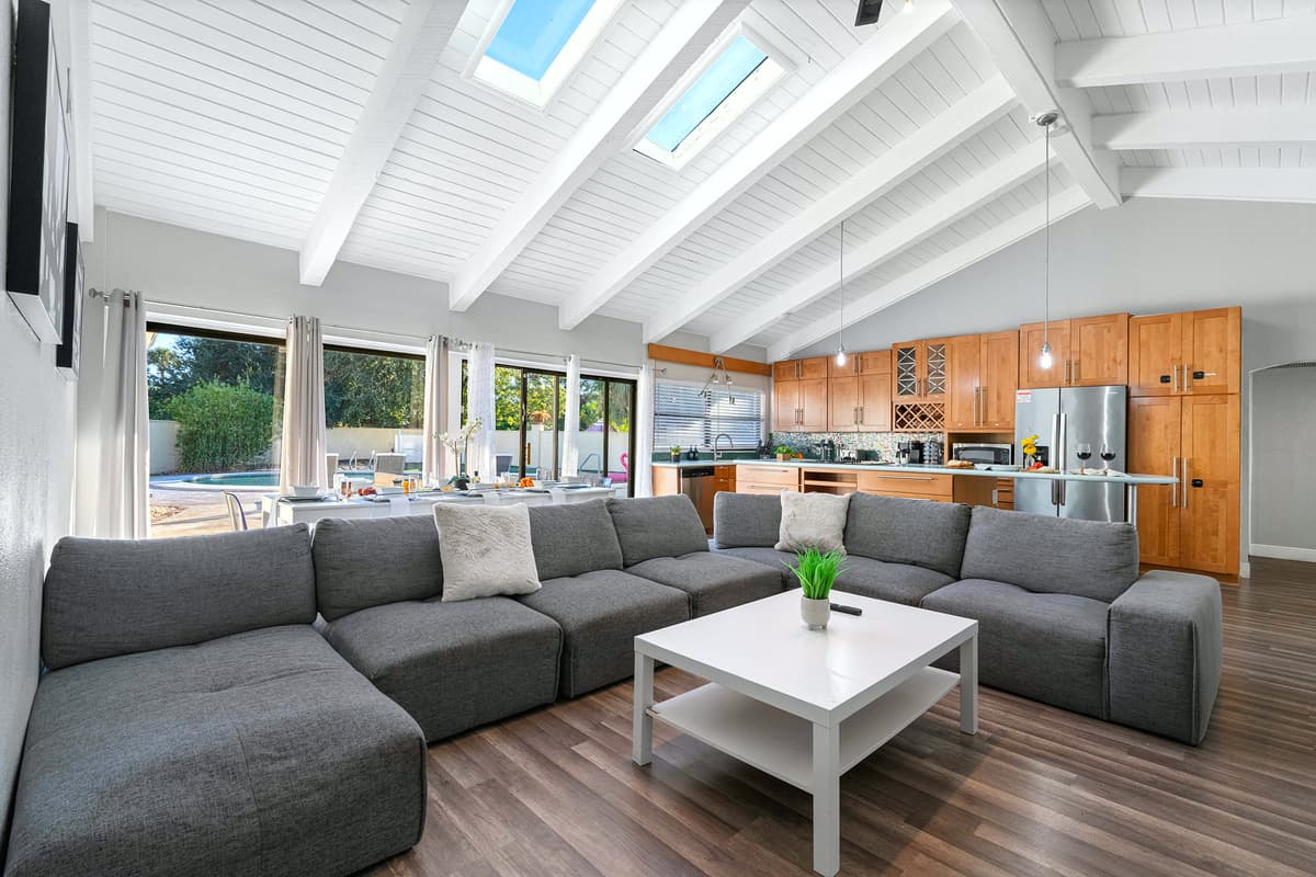 Enjoy natural light streaming through skylights in this open living area — perfect for lounging or movie nights with family and friends.