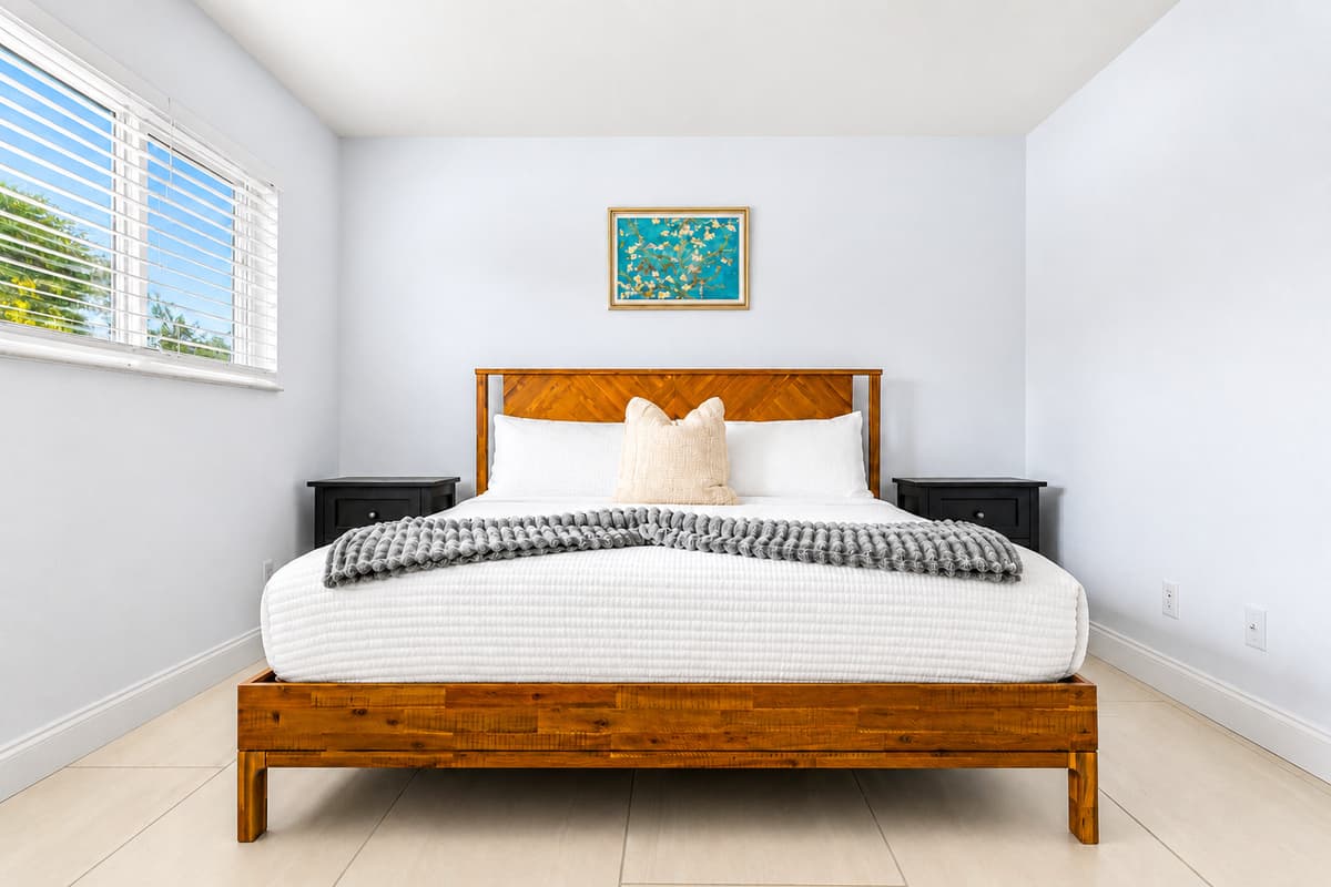 Clean and modern bedroom with plush bedding and bright open layout.
