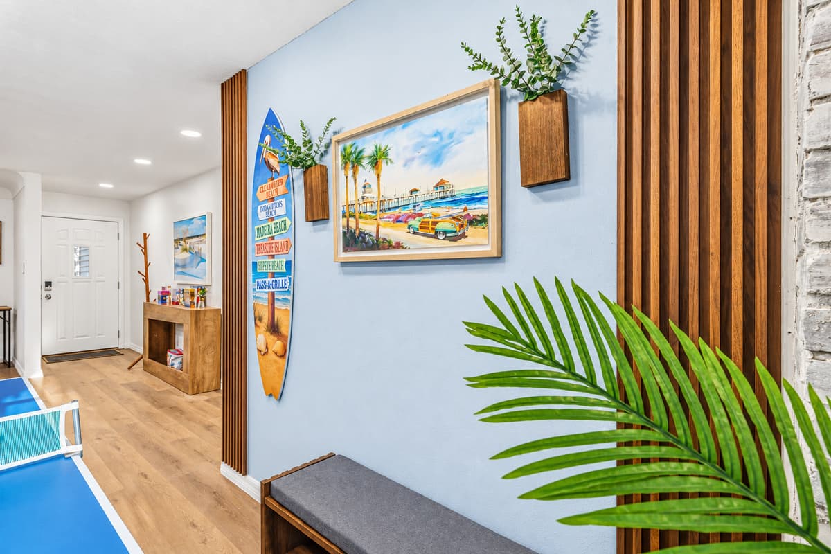 Bright hallway with coastal-inspired décor leading into the main living and game spaces 