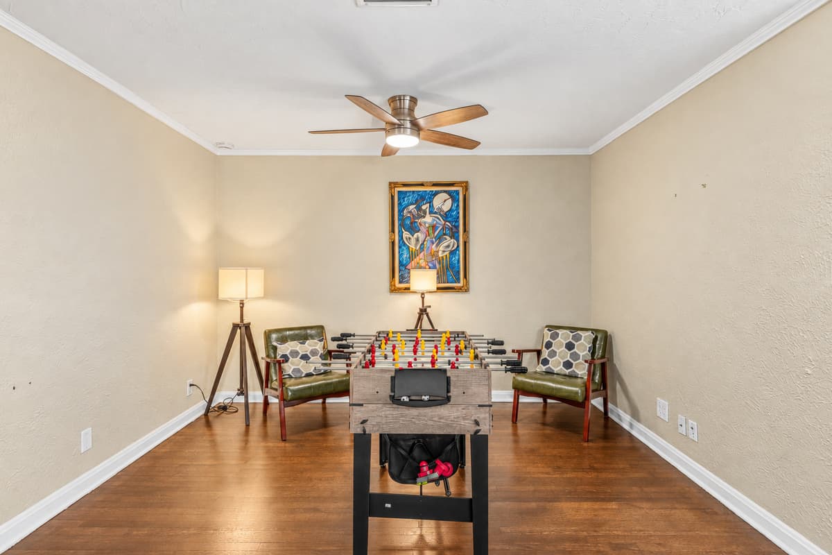 Stylish game room setup with foosball table and lounge chairs for relaxing between games.
