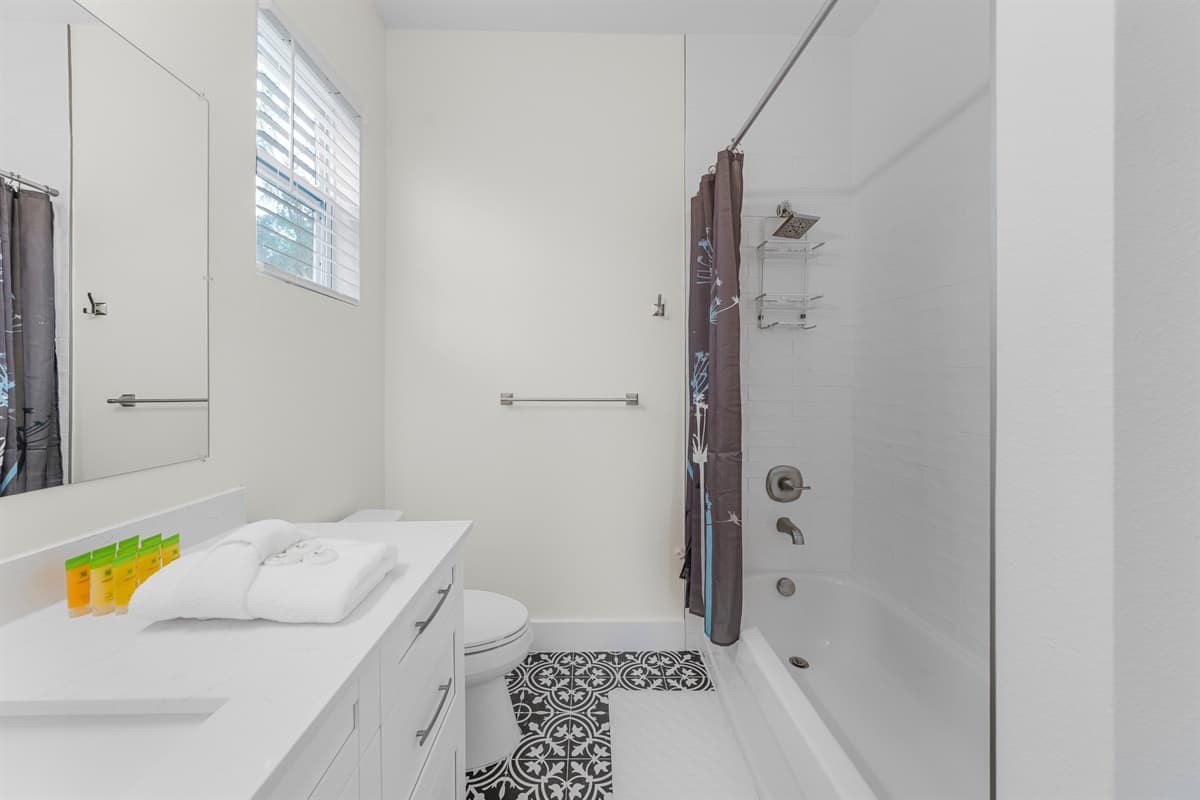 Modern bathroom with tub/shower combo and clean, bright finishes.
