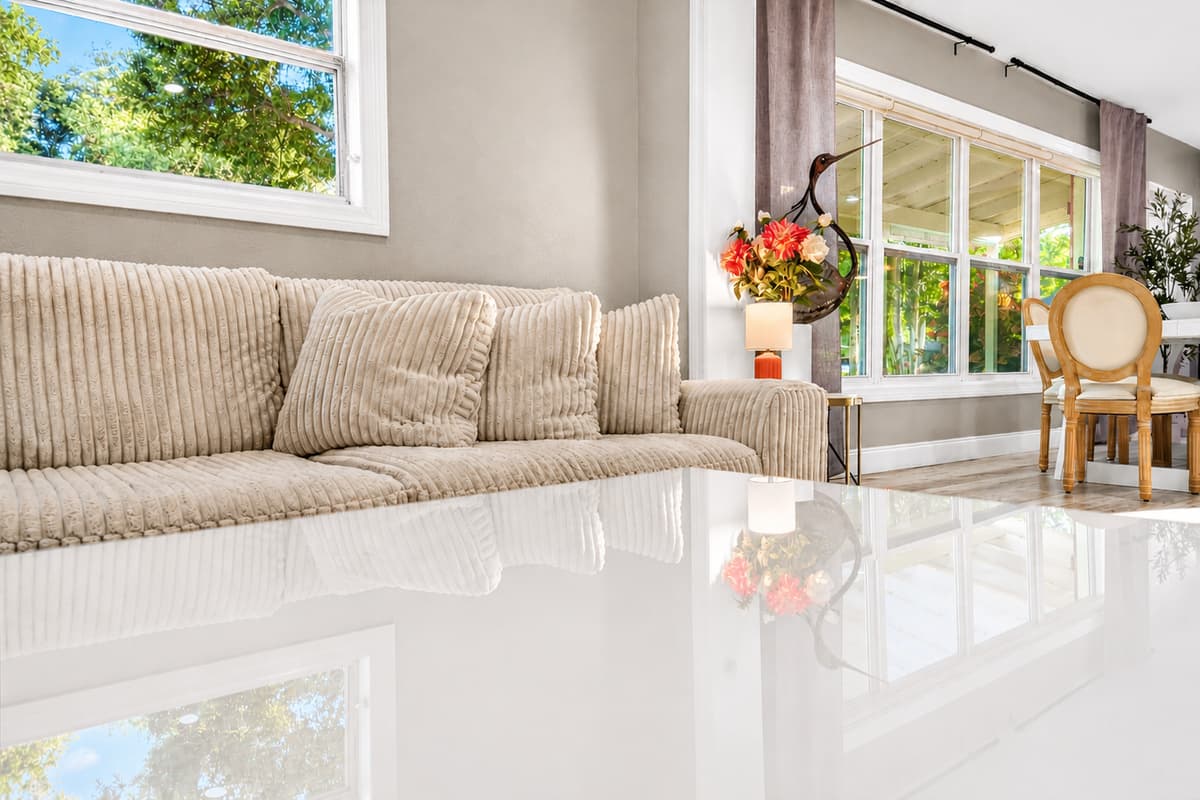 Close-up of the living room seating area highlighting textured upholstery, coffee table reflection, and large windows.