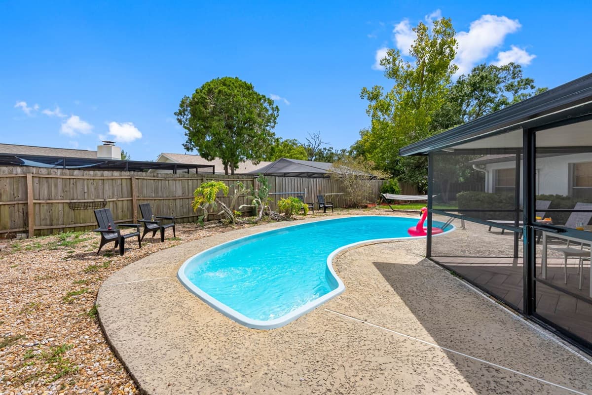 Step into serenity with this crystal-clear pool, surrounded by tropical landscaping and complete privacy—perfect for cooling off or lounging under the sun.