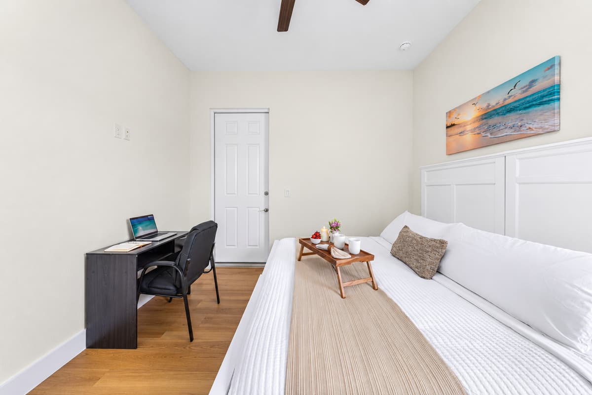 Wake up refreshed in a bright, comfortable bedroom with quality bedding and a handy workspace nearby.