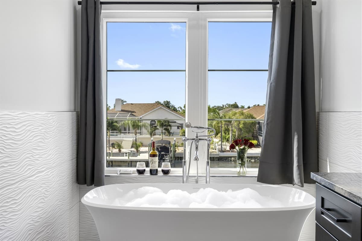 This luxurious full bathroom offers a serene retreat with a large tub positioned by the window.