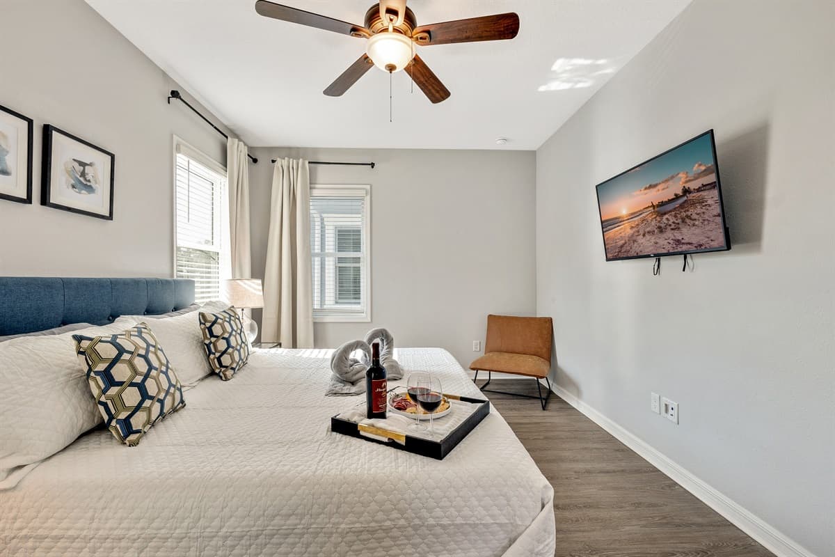 Natural light streams through large windows, casting a warm glow upon the room's tasteful furnishings.