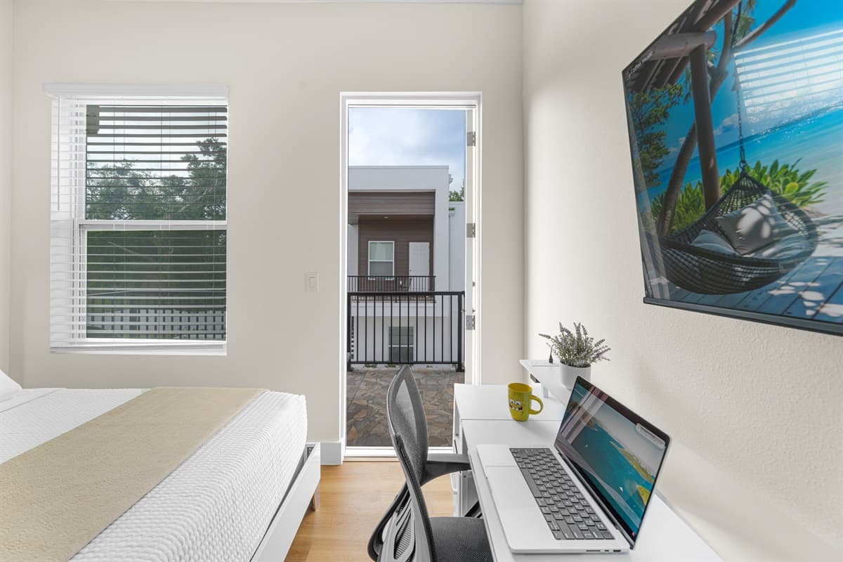 Bright bedroom with a dedicated workspace and direct balcony access—perfect for enjoying natural light and working comfortably.