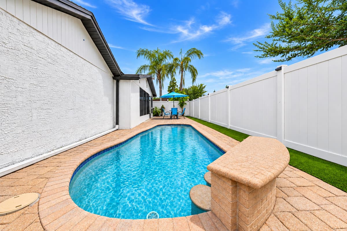 Private swimming pool surrounded by a fully fenced backyard, perfect for cooling off and enjoying sunny Florida days in complete privacy.