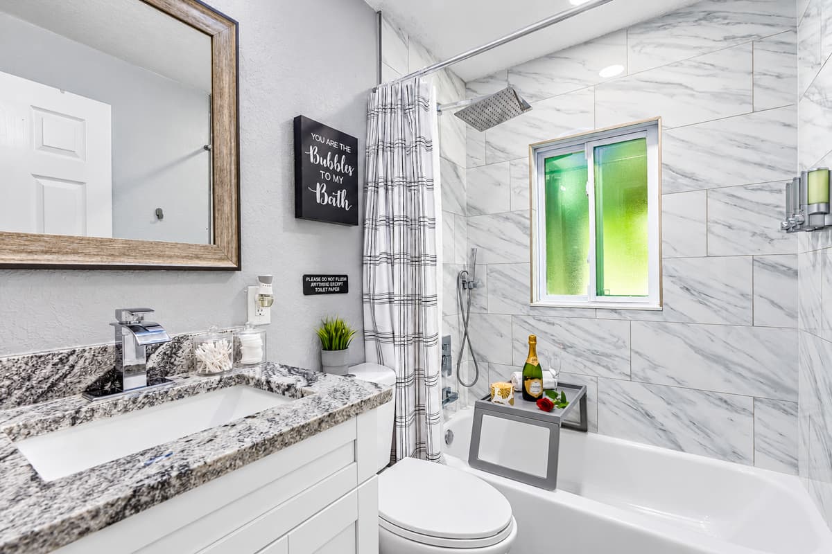 Bubbly bath time, anyone? A full tub with shower, bright window, and a fun bath sign. A clean, bright bathroom for winding down at night. Fresh towels and toiletries included.