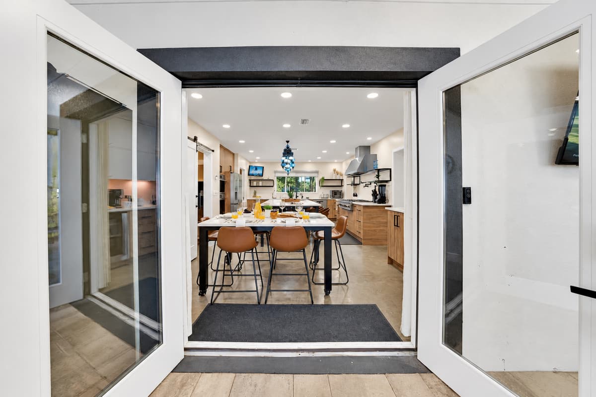Walk through and the kitchen opens up — stools already pulled out for whoever gets there first.