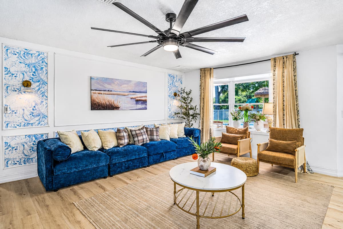 Velvet sectional, rattan chairs, and a marble table in the middle — the corner of the house where nobody looks at their phone.