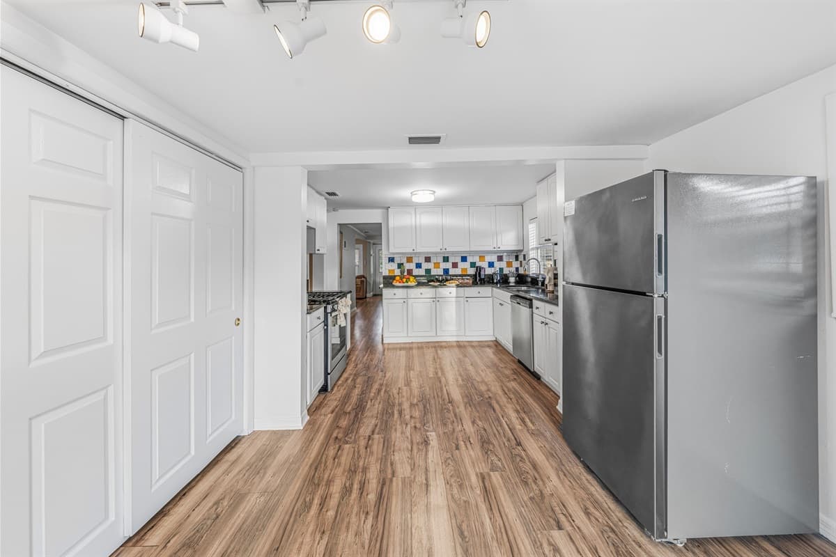 Hallway view showcasing the open flow from kitchen to living spaces.