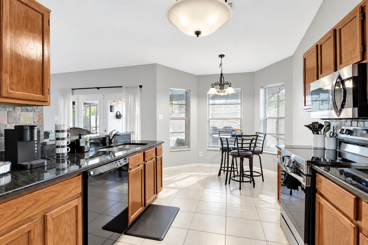 Adorned with rich wooden cupboards and a gleaming black countertop that exudes modern chic.